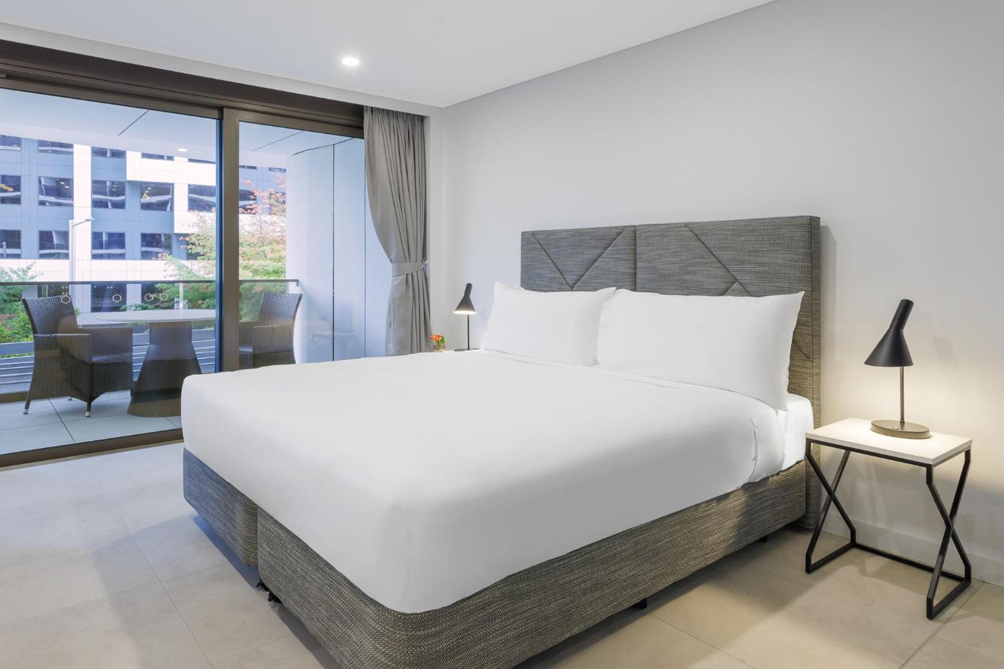Meriton Suites Канберра Экстерьер фото A bed with a mattress